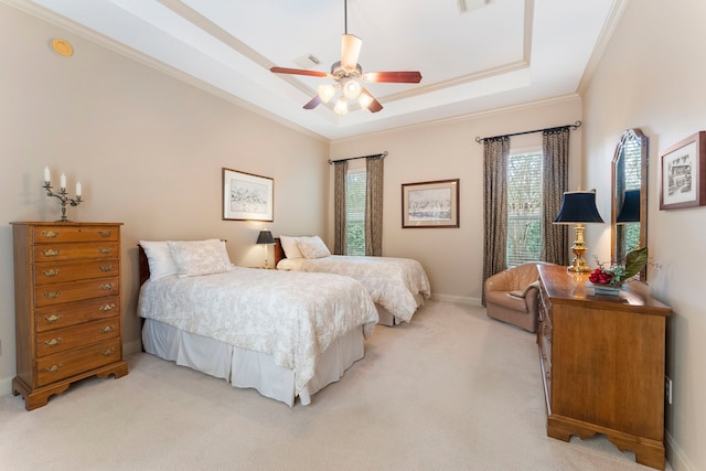 bedroom with a tray ceiling, ornamental molding, visible vents, and light carpet