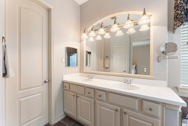 full bath featuring double vanity, tile patterned floors, and a sink