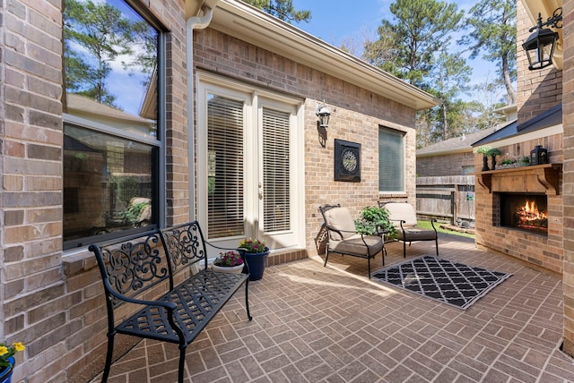 view of patio featuring a warm lit fireplace