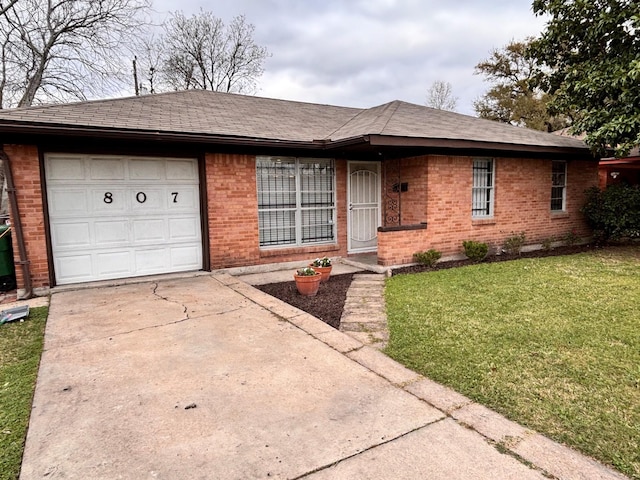 ranch-style house with a front yard, roof with shingles, concrete driveway, a garage, and brick siding