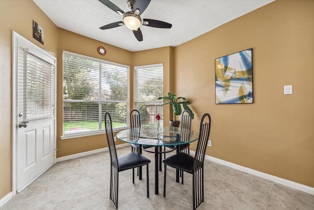 dining room featuring a textured ceiling, baseboards, and ceiling fan