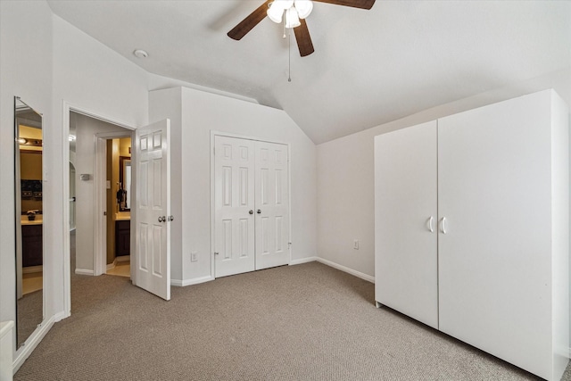 unfurnished bedroom featuring light colored carpet, baseboards, a ceiling fan, and vaulted ceiling