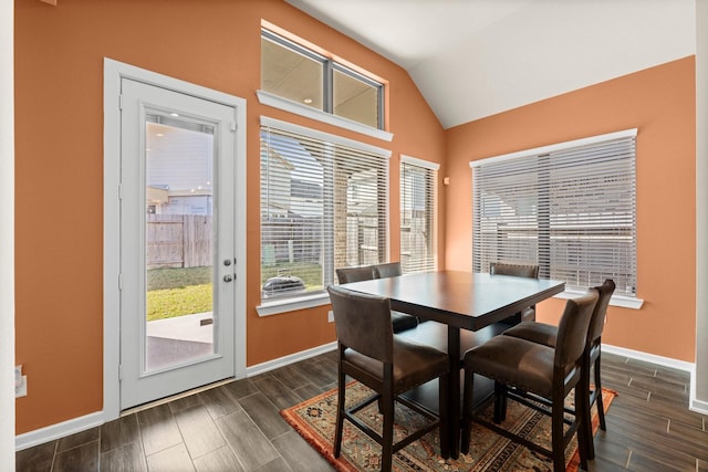 dining room featuring vaulted ceiling, baseboards, and wood tiled floor