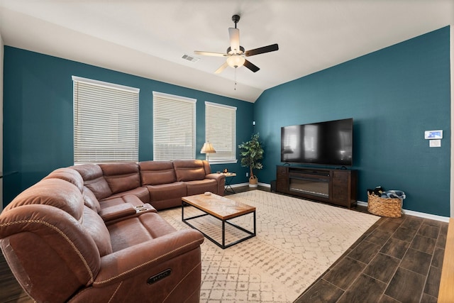 living area with wood finish floors, visible vents, lofted ceiling, baseboards, and ceiling fan