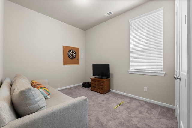 carpeted living area featuring visible vents and baseboards