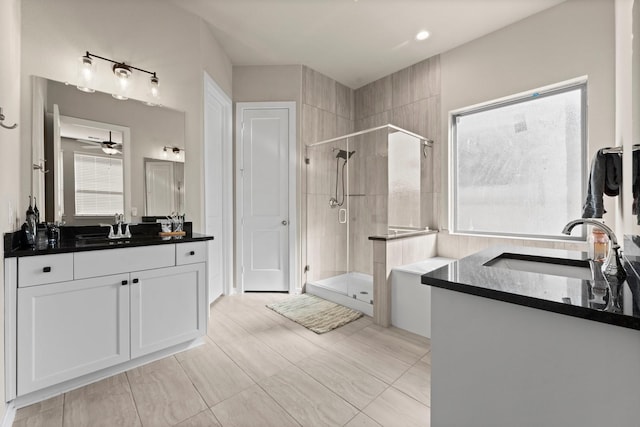 full bathroom featuring a stall shower, two vanities, and a sink