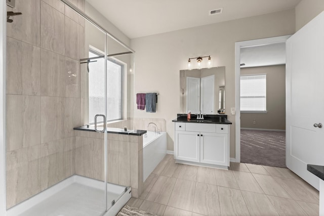 full bathroom with vanity, visible vents, baseboards, a stall shower, and a bath