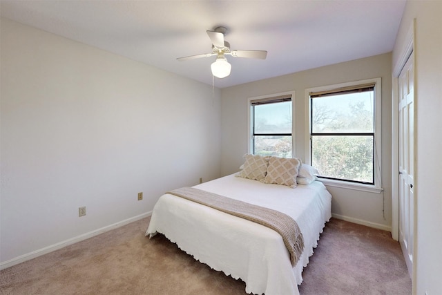 bedroom with baseboards, light colored carpet, and ceiling fan