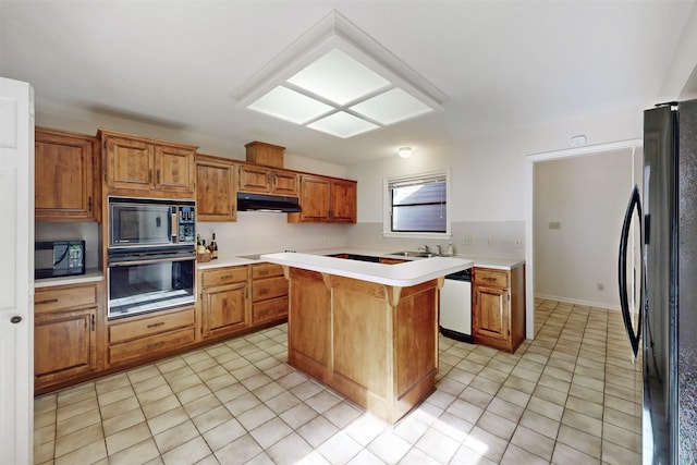 kitchen with black appliances, light tile patterned flooring, light countertops, and under cabinet range hood