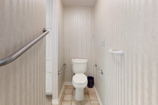 bathroom with tile patterned flooring, toilet, and baseboards