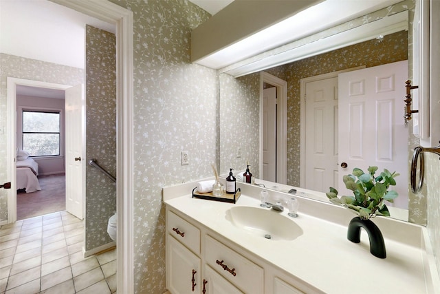 ensuite bathroom with vanity, wallpapered walls, ensuite bath, tile patterned floors, and toilet