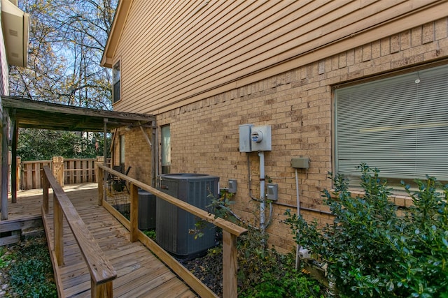 view of home's exterior with a deck, cooling unit, and brick siding