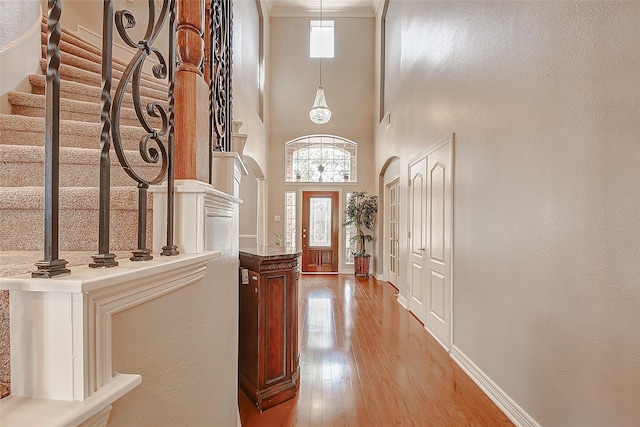 foyer entrance with stairs, light wood-style flooring, a healthy amount of sunlight, and baseboards