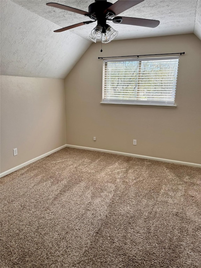 bonus room with baseboards, a textured ceiling, and carpet