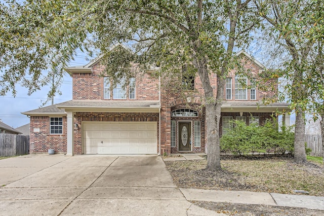 traditional home with brick siding, driveway, a garage, and fence