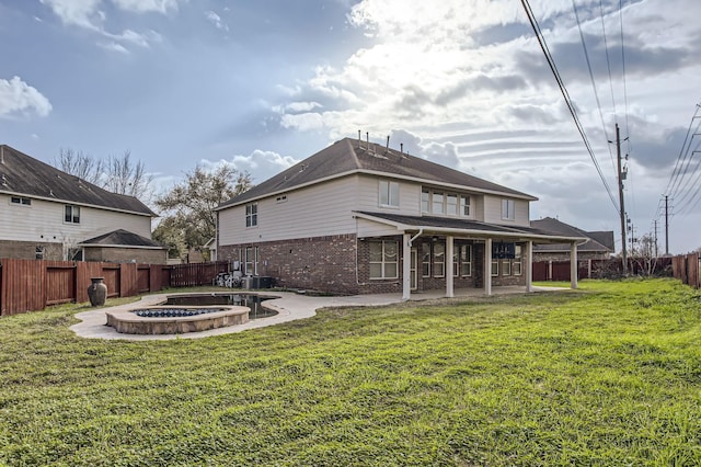 back of property featuring brick siding, a fenced backyard, a yard, and a patio