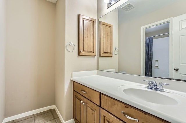 bathroom featuring tile patterned floors, visible vents, vanity, and baseboards