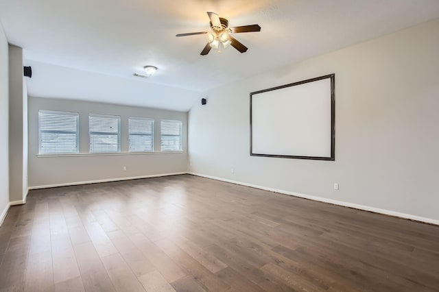 empty room with baseboards, dark wood-type flooring, a ceiling fan, and vaulted ceiling