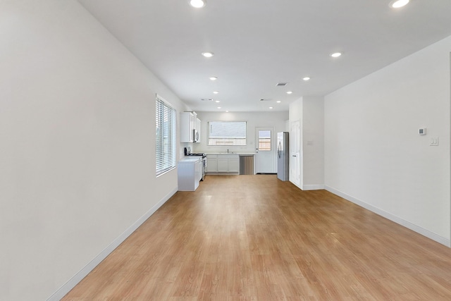 unfurnished living room featuring recessed lighting, light wood-type flooring, baseboards, and visible vents