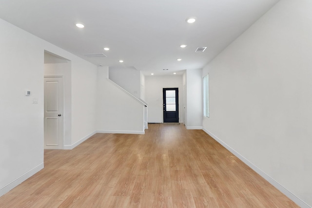 empty room featuring visible vents, recessed lighting, light wood-type flooring, and baseboards