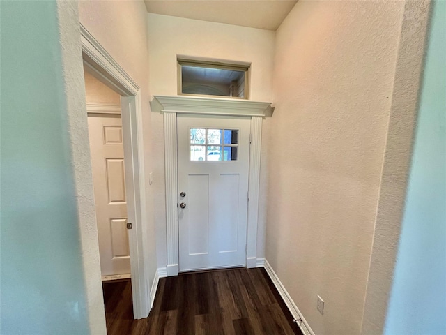 doorway to outside featuring dark wood-type flooring and baseboards