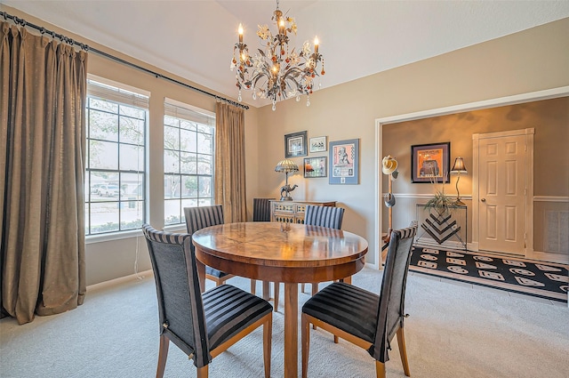 dining space with carpet, baseboards, and a chandelier