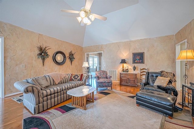 living area with visible vents, wood finished floors, a ceiling fan, and vaulted ceiling