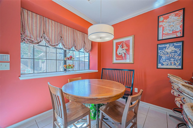 dining room with tile patterned flooring, crown molding, and baseboards