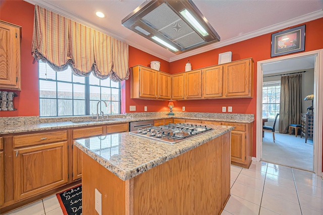 kitchen with a center island, ornamental molding, light tile patterned flooring, stainless steel appliances, and a sink