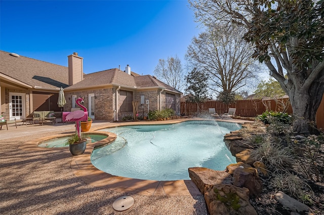 view of pool featuring a patio area, a pool with connected hot tub, and a fenced backyard