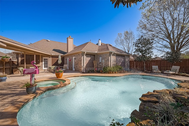 view of swimming pool with a patio, a fenced backyard, and a pool with connected hot tub