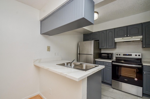 kitchen with under cabinet range hood, gray cabinetry, stainless steel appliances, and a sink