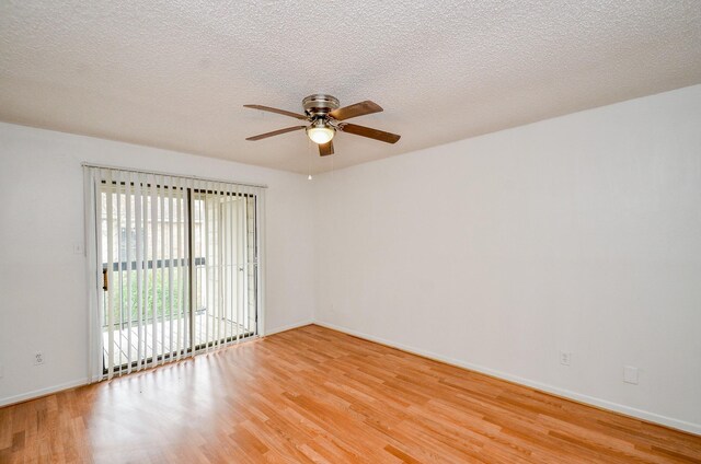 unfurnished room featuring light wood-type flooring, baseboards, and a textured ceiling