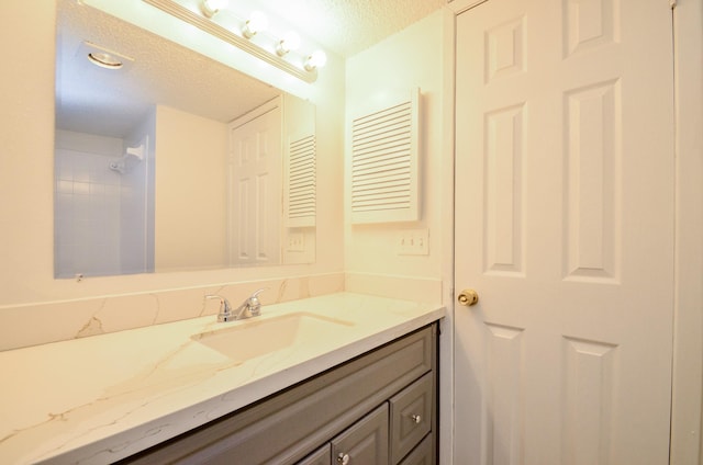 bathroom featuring a textured ceiling and vanity