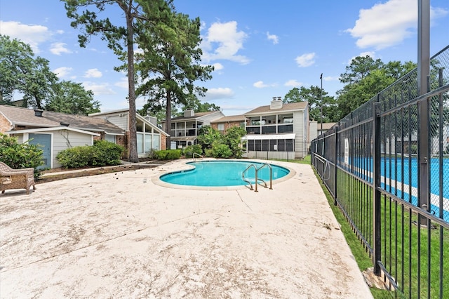 view of swimming pool featuring a patio area, a fenced in pool, and fence