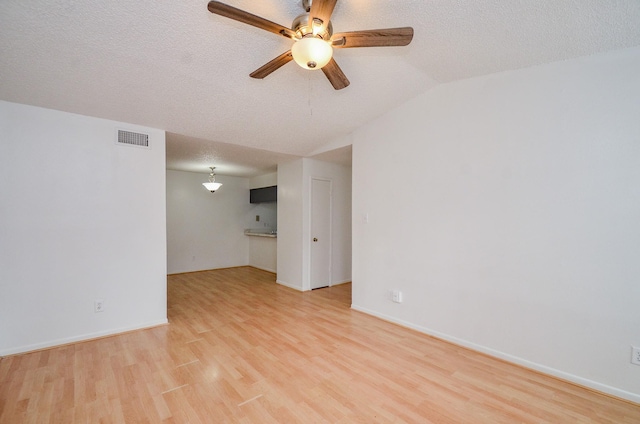 unfurnished room with light wood-style floors, visible vents, and a textured ceiling