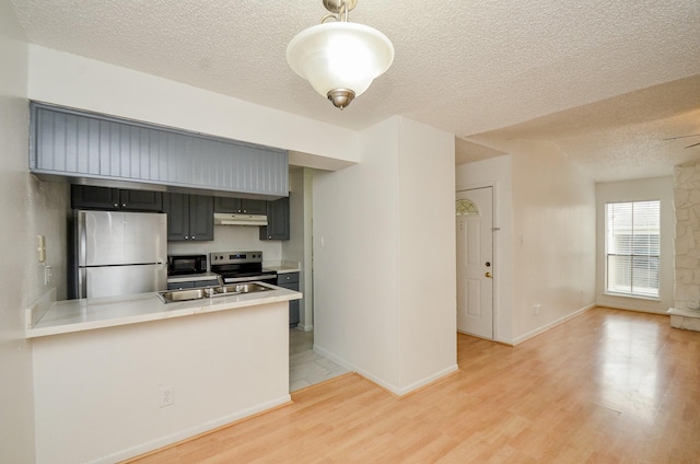 kitchen featuring under cabinet range hood, appliances with stainless steel finishes, light wood-type flooring, and a peninsula