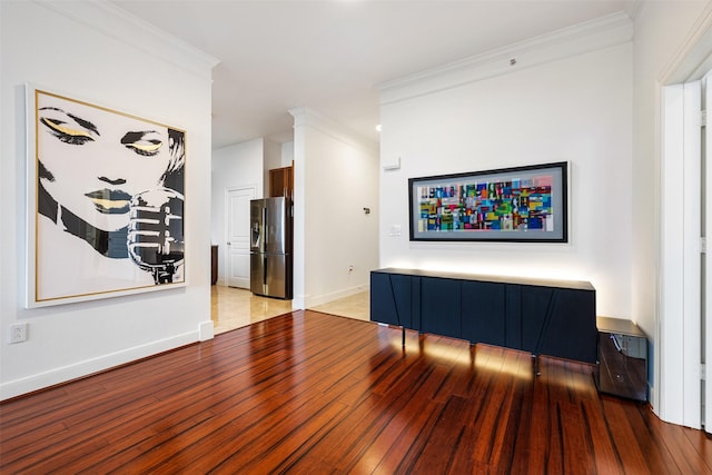 living room featuring crown molding, baseboards, and wood-type flooring