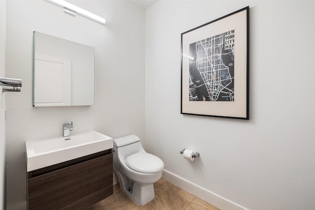 bathroom featuring vanity, toilet, baseboards, and tile patterned flooring