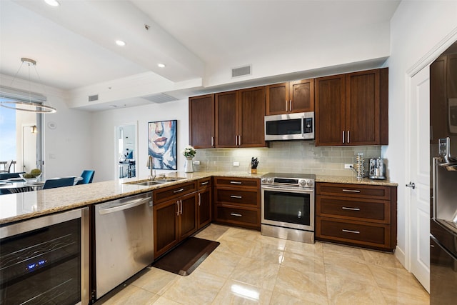 kitchen with visible vents, beverage cooler, a sink, backsplash, and stainless steel appliances