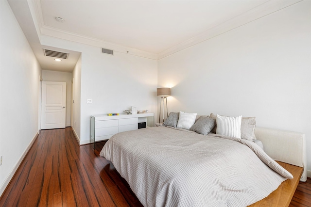 bedroom with visible vents, baseboards, and hardwood / wood-style flooring