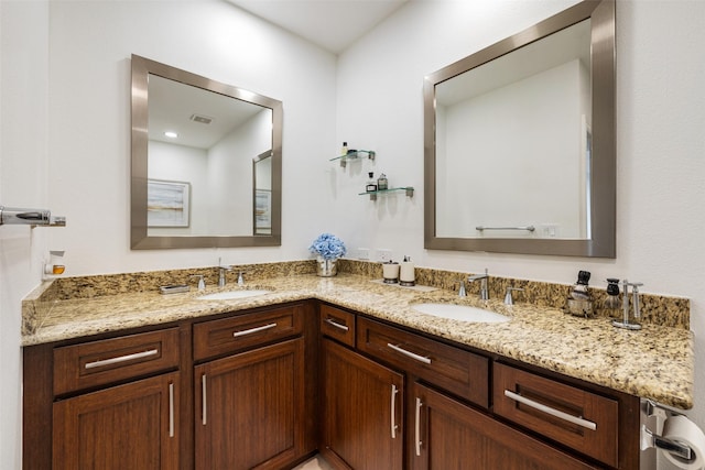 bathroom with double vanity, visible vents, and a sink