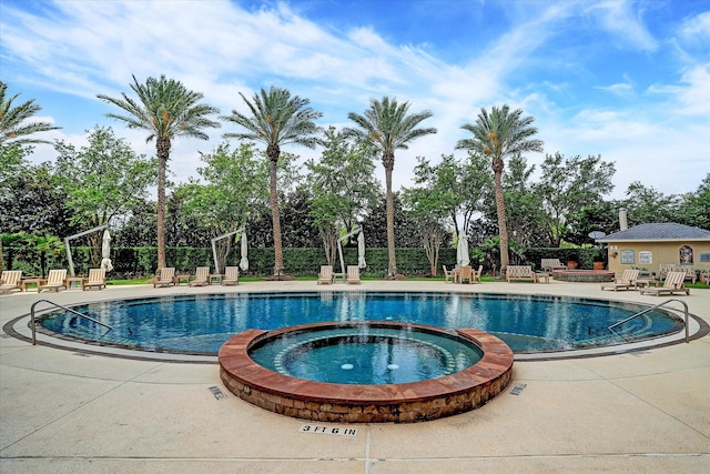 view of swimming pool with a patio area and a pool with connected hot tub