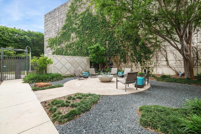 view of patio featuring a gate, a fire pit, and fence