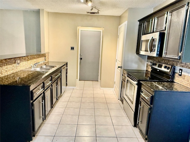 kitchen featuring visible vents, appliances with stainless steel finishes, light tile patterned flooring, a textured ceiling, and a sink