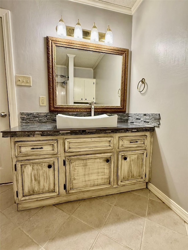 bathroom with tile patterned floors, vanity, baseboards, and ornamental molding