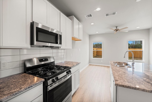 kitchen featuring tasteful backsplash, visible vents, appliances with stainless steel finishes, and a sink