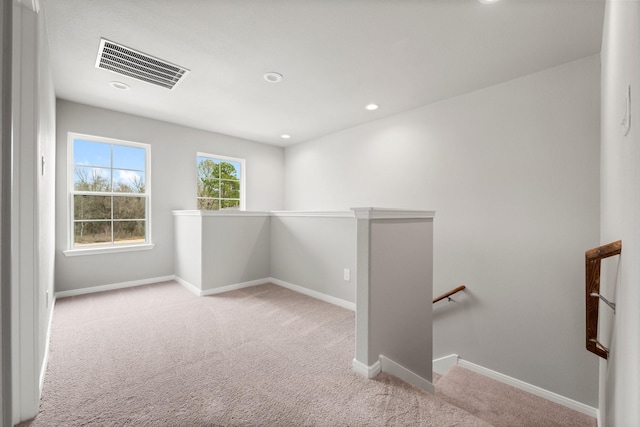 unfurnished room with visible vents, baseboards, and carpet floors