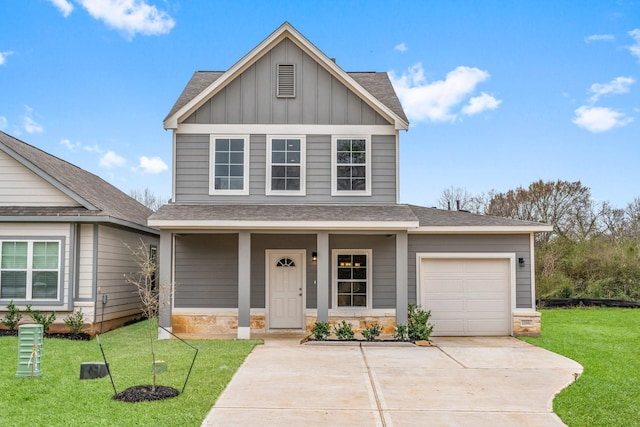 view of front of property with board and batten siding, a front lawn, driveway, stone siding, and an attached garage