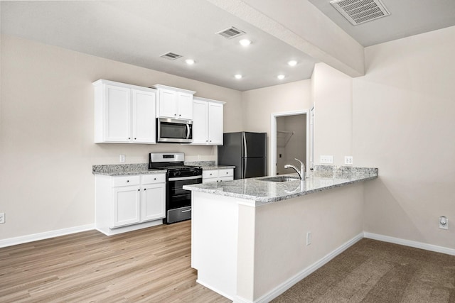 kitchen featuring visible vents, stainless steel appliances, baseboards, and a sink